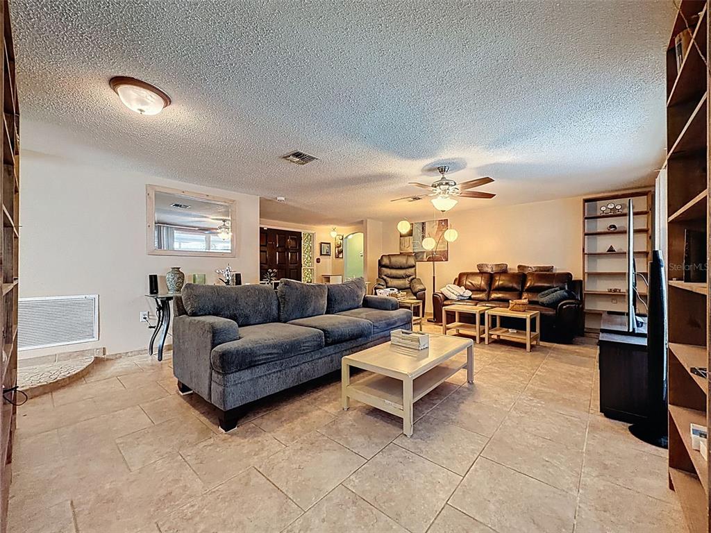 9610 Rainbow Lane Port Richey, FL 34668 - Photo 9 of 34 a living room with furniture and a flat screen tv