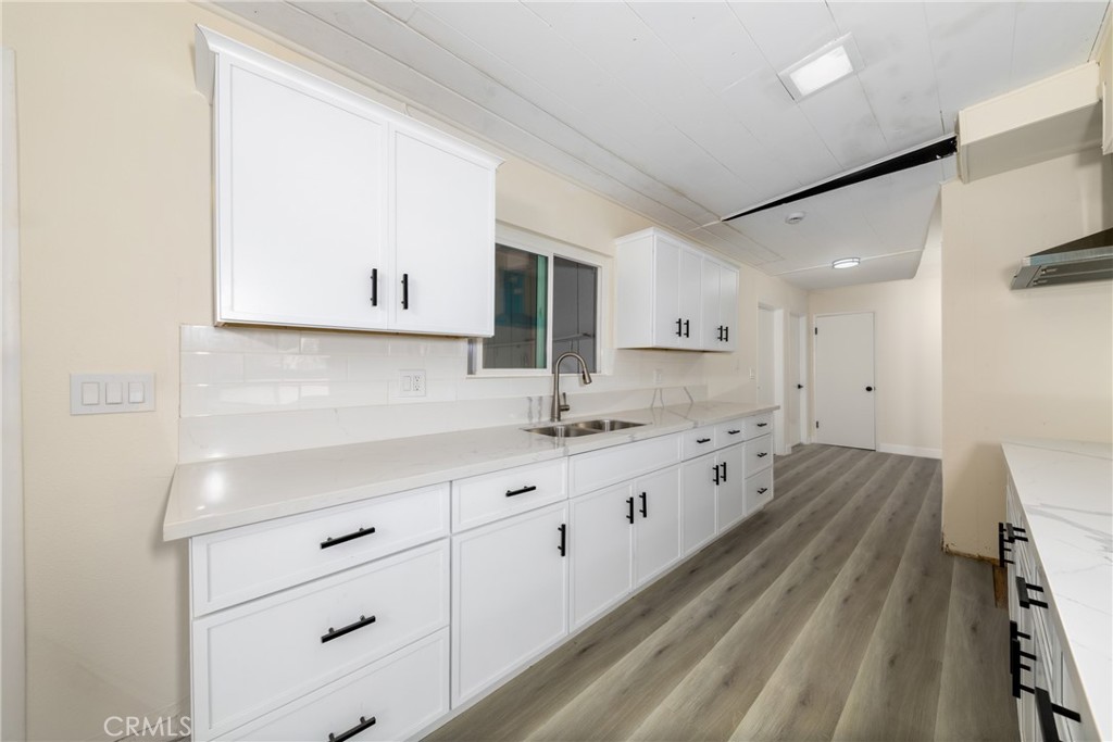 12449 6th Street Yucaipa, CA 92399 - Photo 13 of 37 a large kitchen with granite countertop a large white cabinets and a dishwasher
