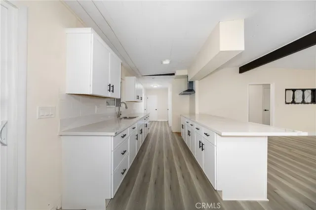 a view of an empty room with wooden floor and windows