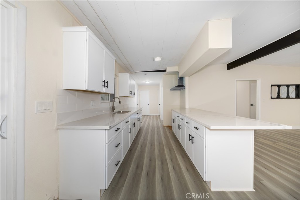 12449 6th Street Yucaipa, CA 92399 - Photo 15 of 37 a kitchen with cabinets a sink and wooden floor
