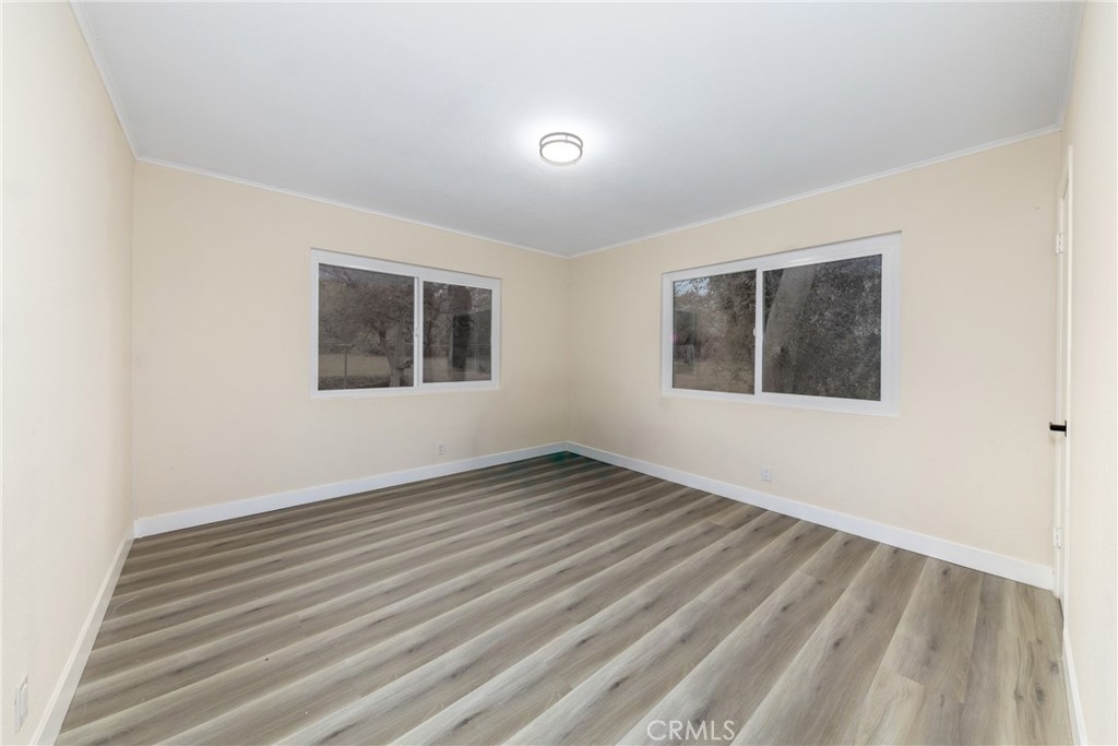 12449 6th Street Yucaipa, CA 92399 - Photo 29 of 37 a view of an empty room with wooden floor and a window