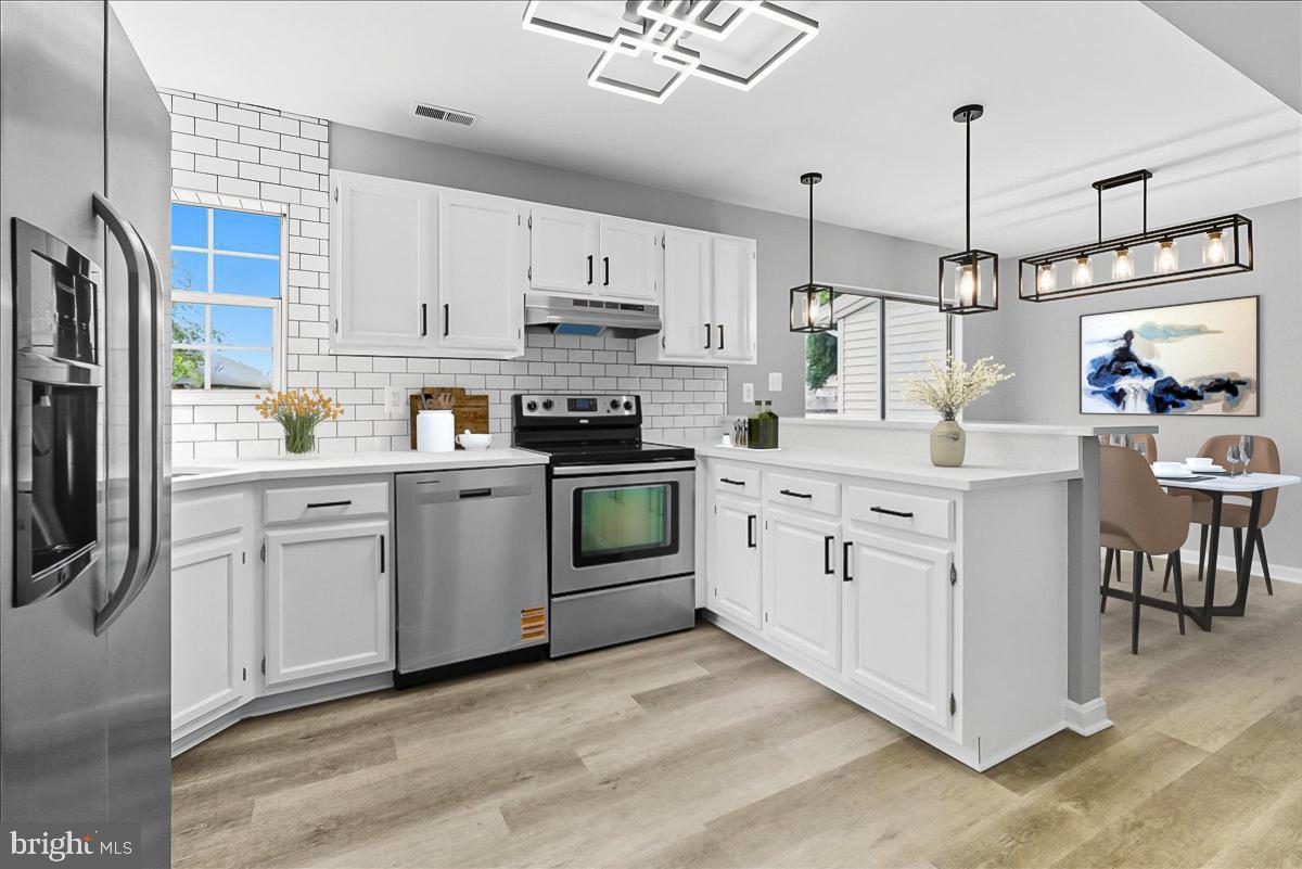 a kitchen with white cabinets stainless steel appliances and sink