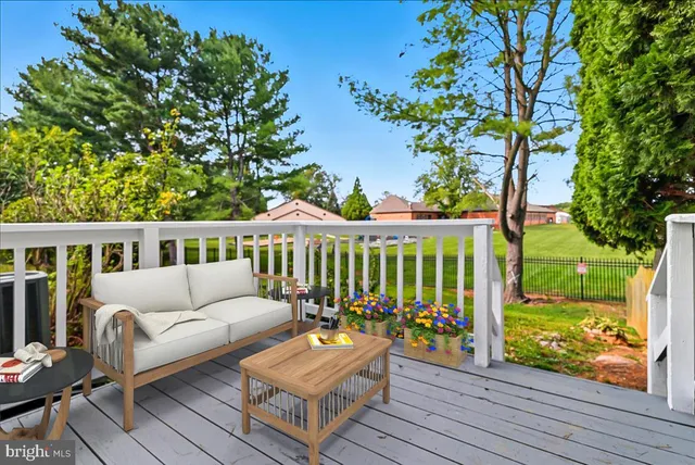 a view of a house with wooden deck and furniture