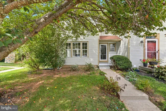 a front view of a house with a yard and potted plants
