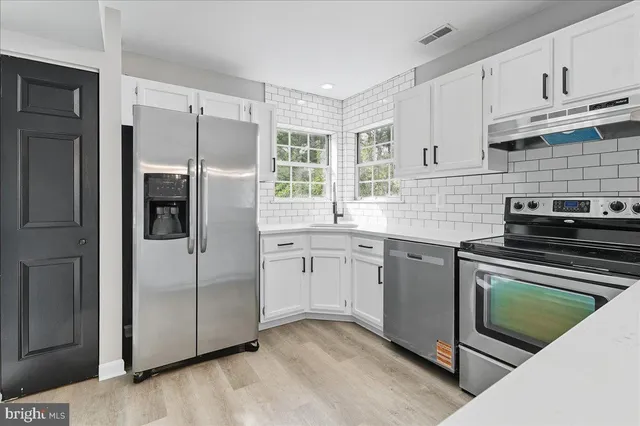 a kitchen with a refrigerator sink and cabinets