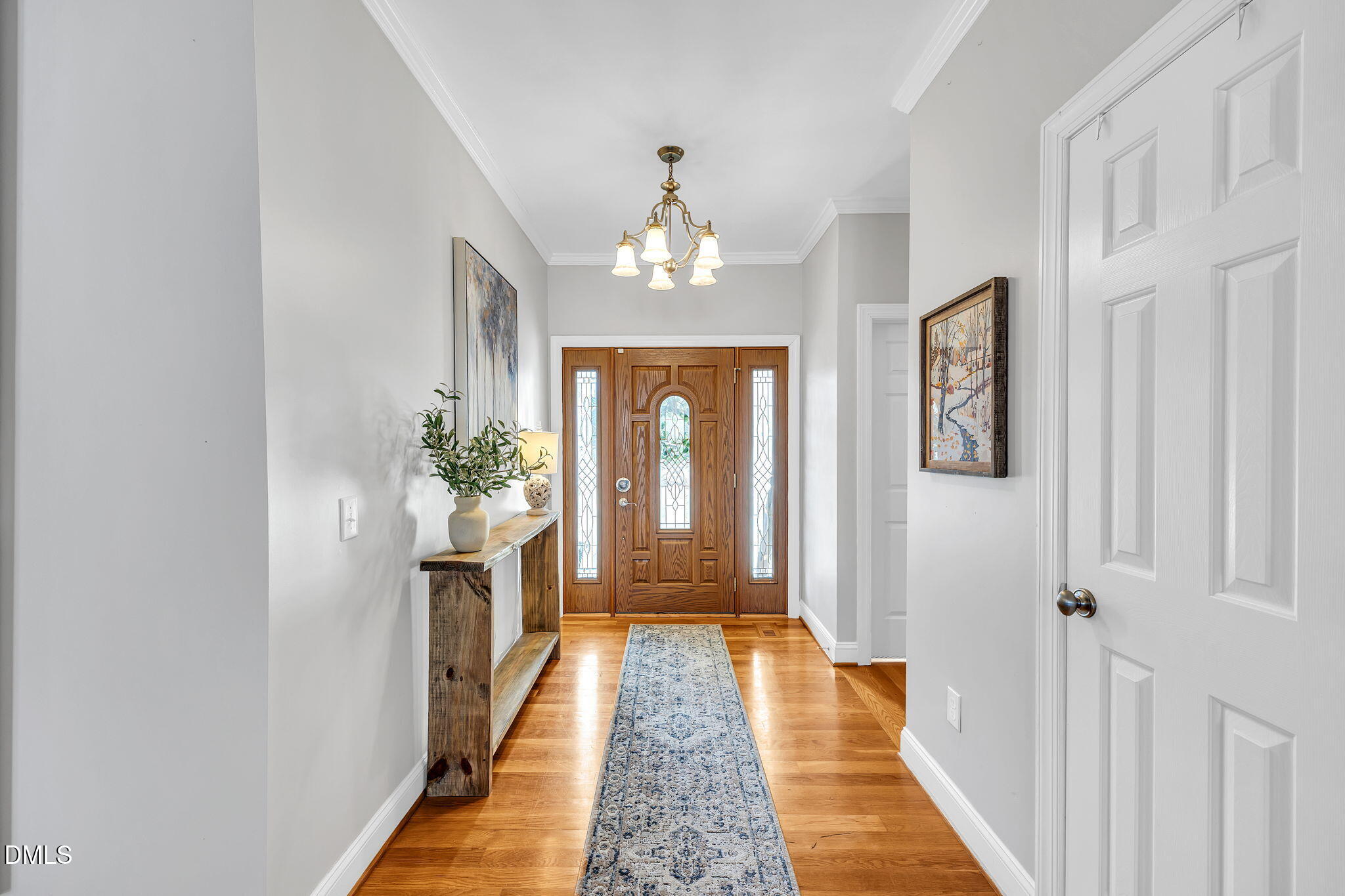 1869 Firetower Road Selma, NC 27576 - Photo 15 of 67 a view of a hallway with wooden floor and a chandelier