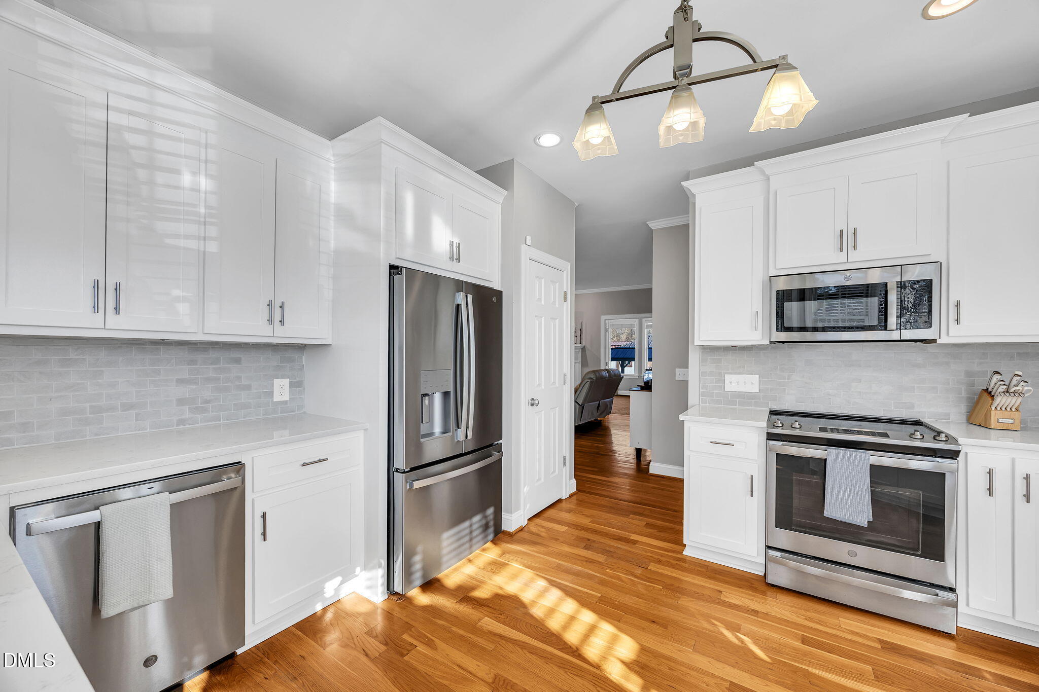 1869 Firetower Road Selma, NC 27576 - Photo 29 of 67 a kitchen with white cabinets stainless steel appliances and chandelier