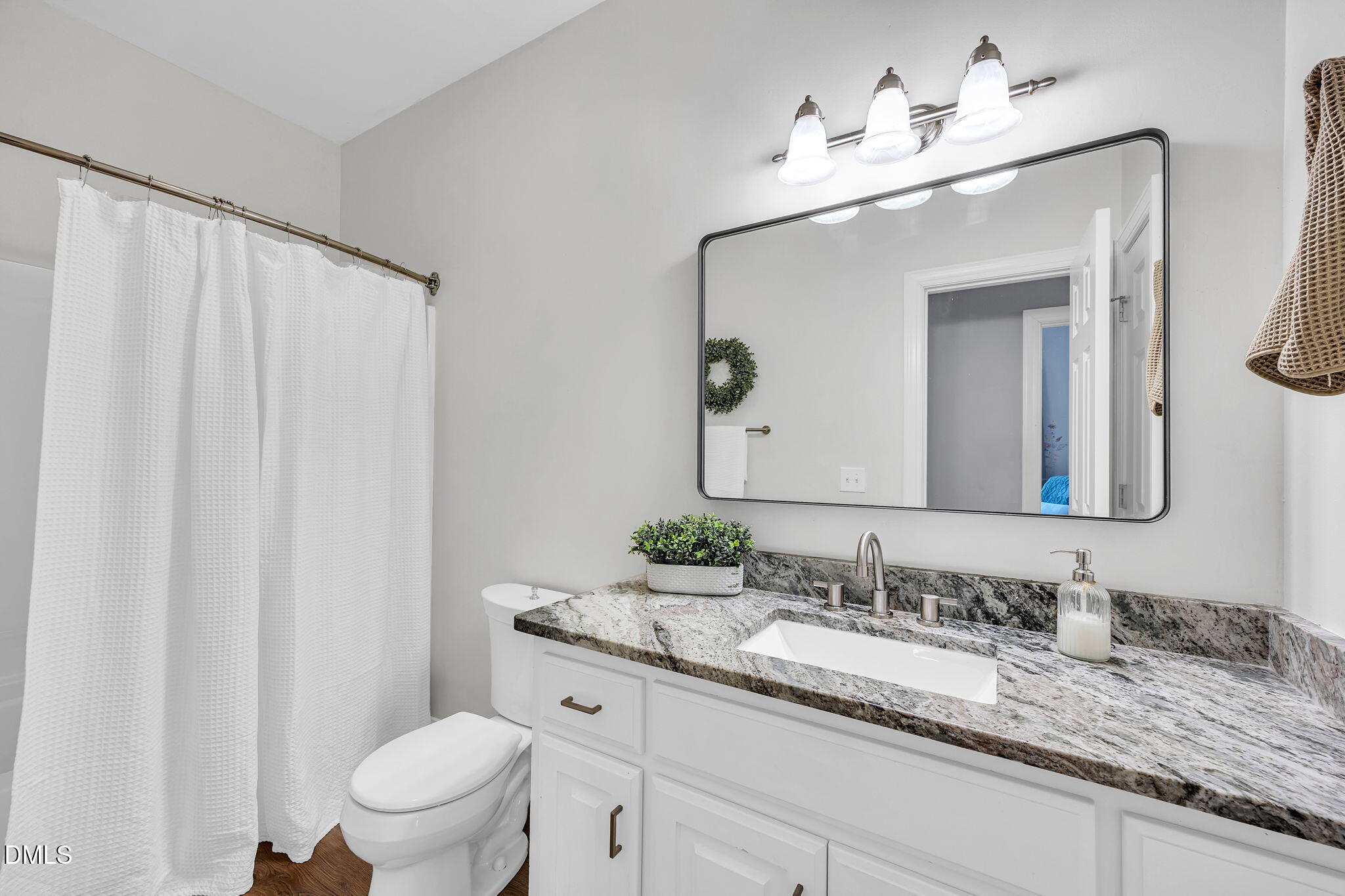 1869 Firetower Road Selma, NC 27576 - Photo 48 of 67 a bathroom with a granite countertop sink and a mirror with toilet