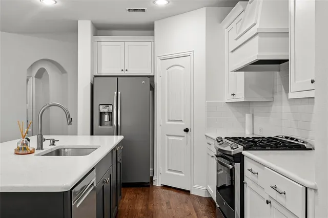 a kitchen with stainless steel appliances granite countertop a sink stove and refrigerator