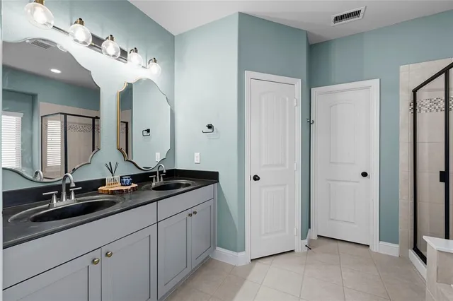 a spacious bathroom with a double vanity sink and a mirror
