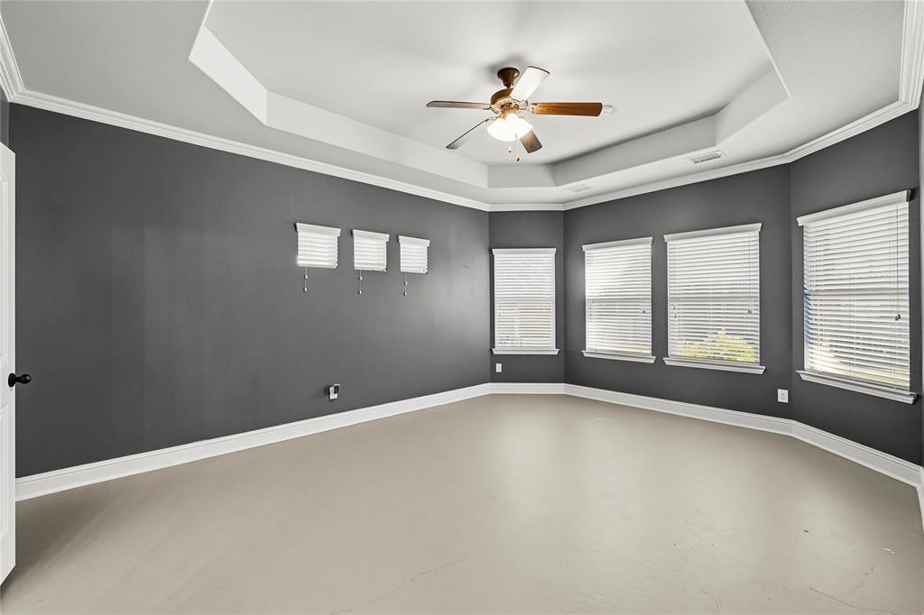 1102 Brigham Drive Forney, TX 75126 - Photo 19 of 30 Spare room with a tray ceiling, ceiling fan, finished concrete floors, and ornamental molding