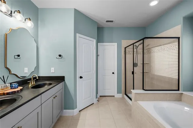 a spacious bathroom with a double vanity sink and a mirror