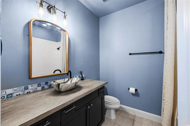 a bathroom with a granite countertop sink mirror and toilet