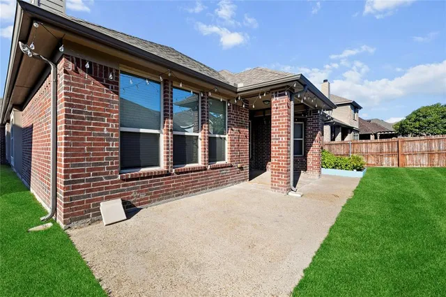 a backyard of a house with a garden and barbeque oven