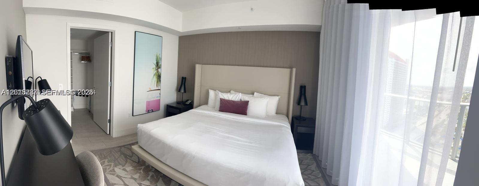 4010 South Ocean Drive, Unit R2004 Hollywood, FL 33019 - Photo 21 of 28 a bedroom with a bed next to a window with the outer view