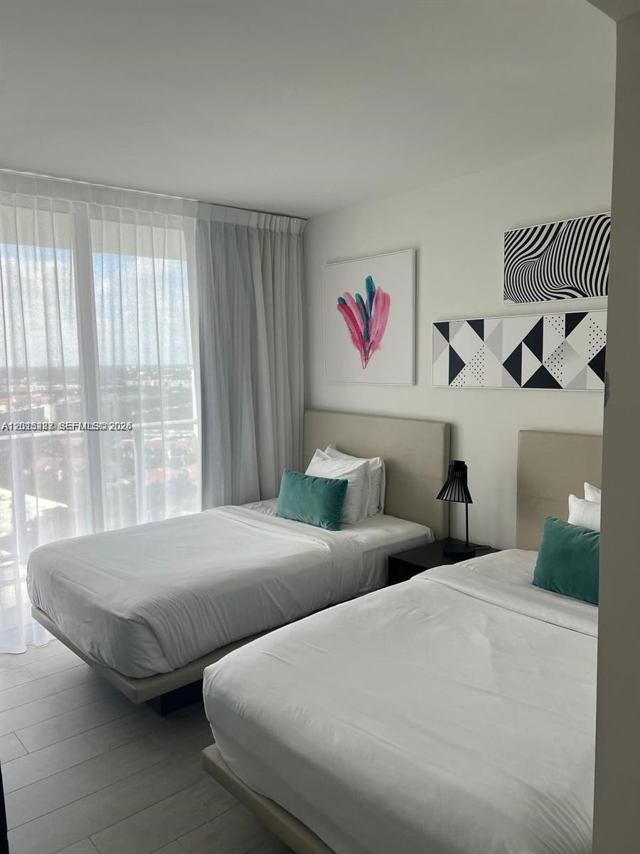 4010 South Ocean Drive, Unit R2004 Hollywood, FL 33019 - Photo 24 of 28 a bedroom with two beds and a large window