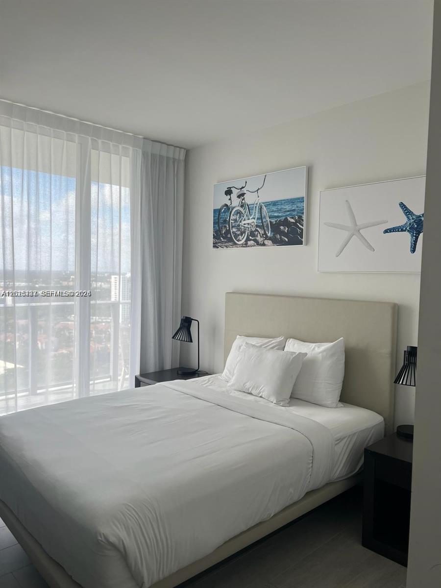 4010 South Ocean Drive, Unit R2004 Hollywood, FL 33019 - Photo 26 of 28 a bedroom with a large bed and a window