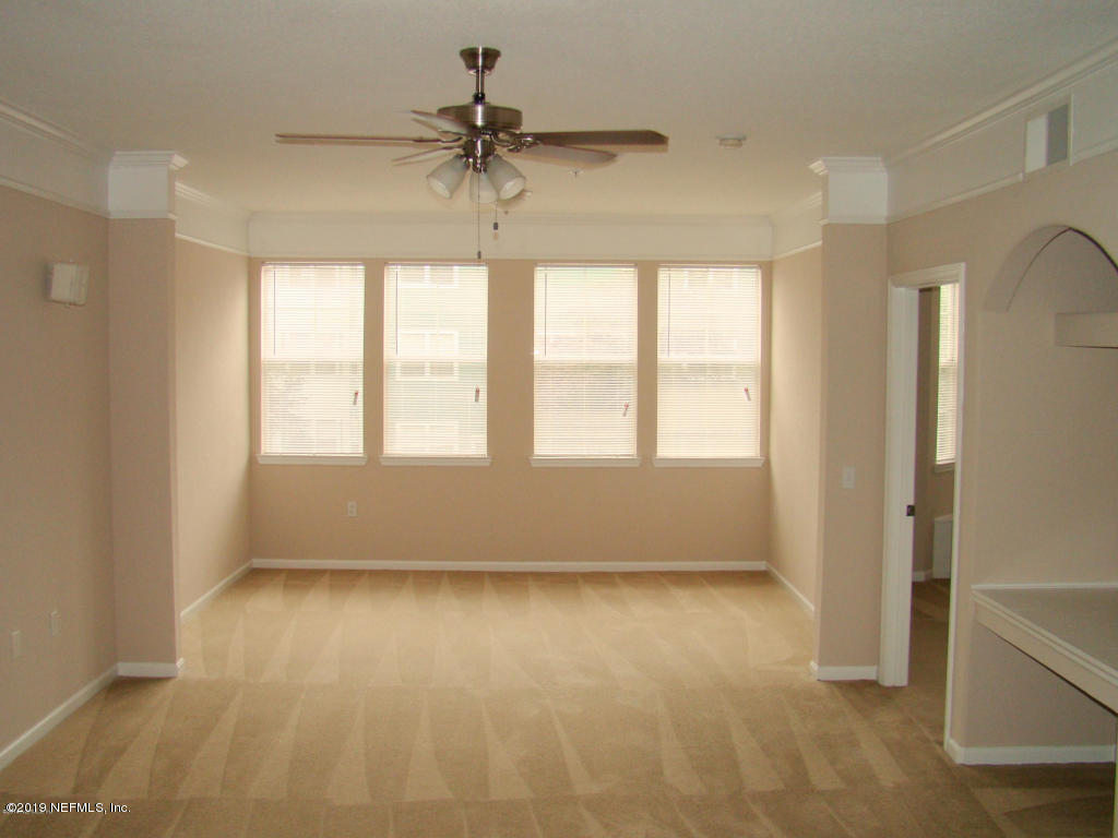 a view of room with window and a ceiling fan