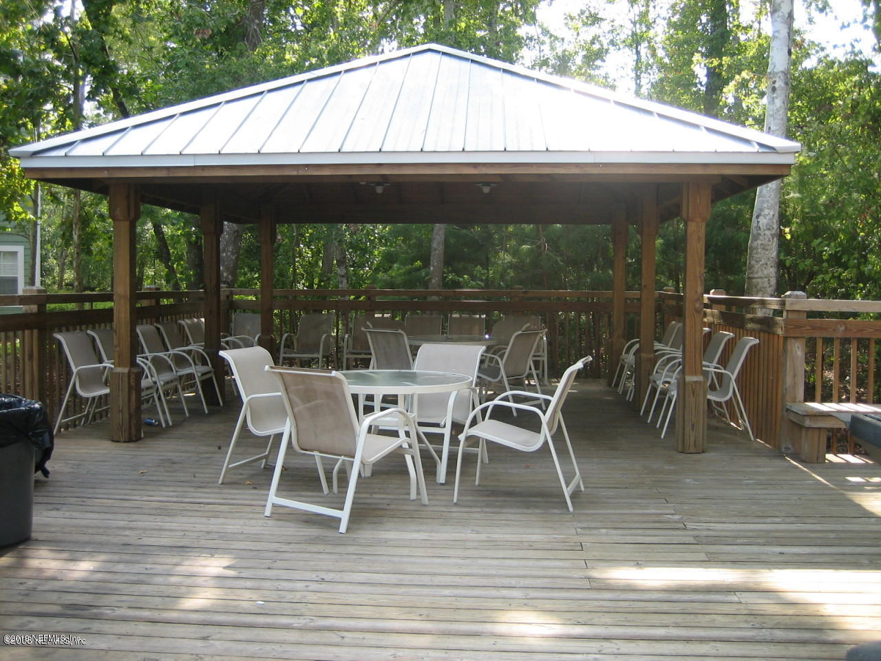 8550 Touchton Road, Unit 323 Jacksonville, FL 32216 - Photo 19 of 19 a patio with wooden floor a yard a table and chairs