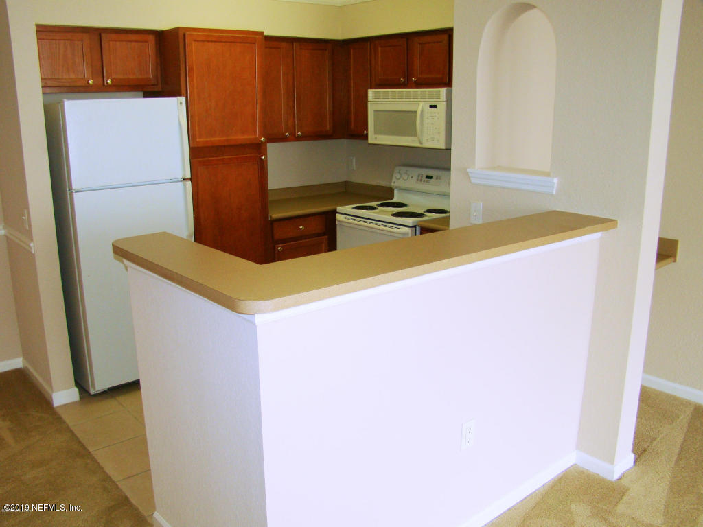 8550 Touchton Road, Unit 323 Jacksonville, FL 32216 - Photo 5 of 19 a kitchen with a refrigerator and a stove