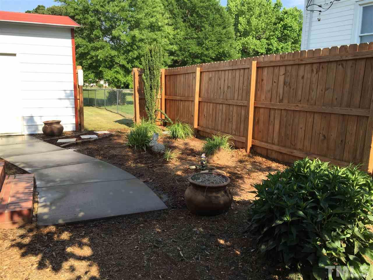 1953 Old Durham Road Roxboro, NC 27573 - Photo 4 of 10 a view of a backyard with plants and wooden fence