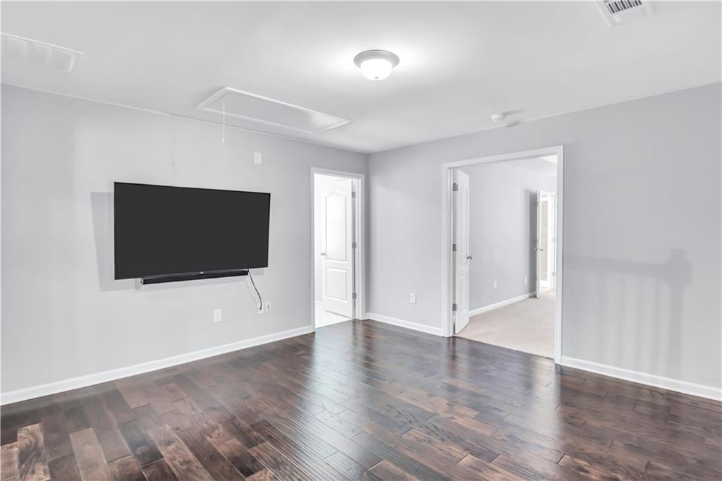 330 Avalon Square Fairburn, GA 30213 - Photo 18 of 52 a view of a livingroom with wooden floor and a flat screen tv