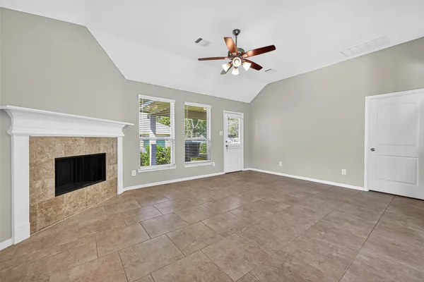 a view of an empty room with a fireplace and a window