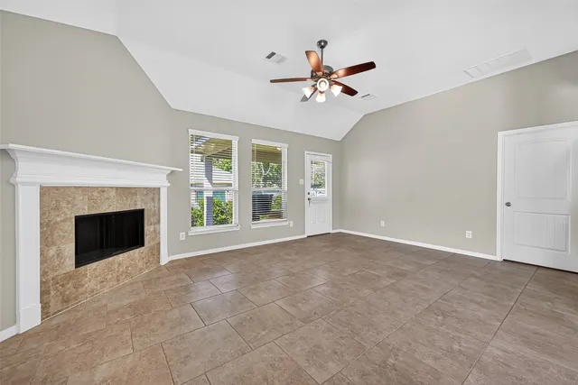 a view of an empty room with a fireplace and a window