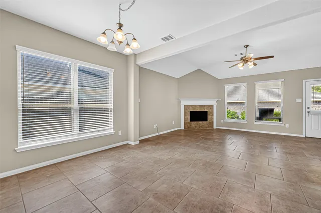 a view of an empty room with a fireplace and a window