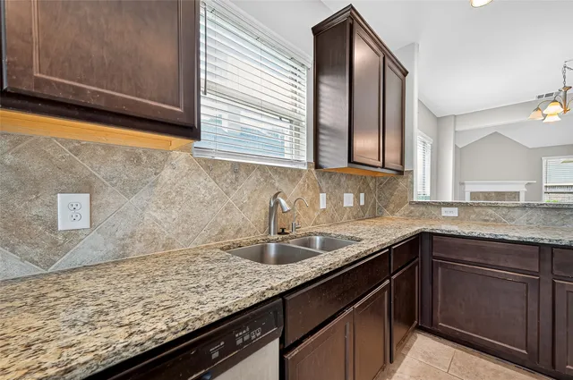 a bathroom with a granite countertop sink and a large mirror