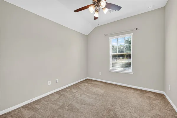 an empty room with chandelier fan