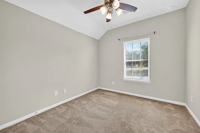 an empty room with chandelier fan