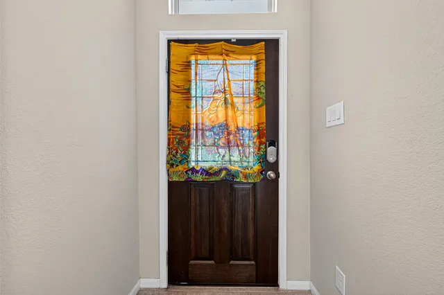 a view of an empty room with a window and bathroom