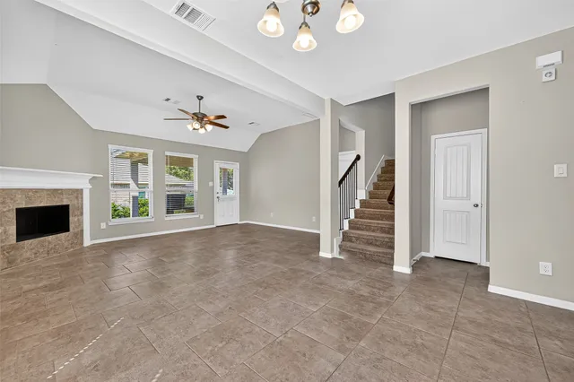 a view of an empty room with a fireplace and a window