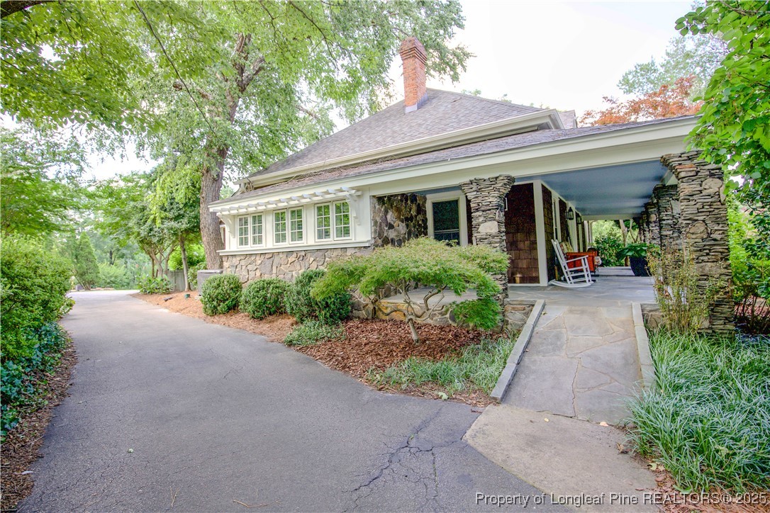 200 Cameron Avenue Vass, NC 28394 - Photo 28 of 50 a view of a house with potted plants and a large tree