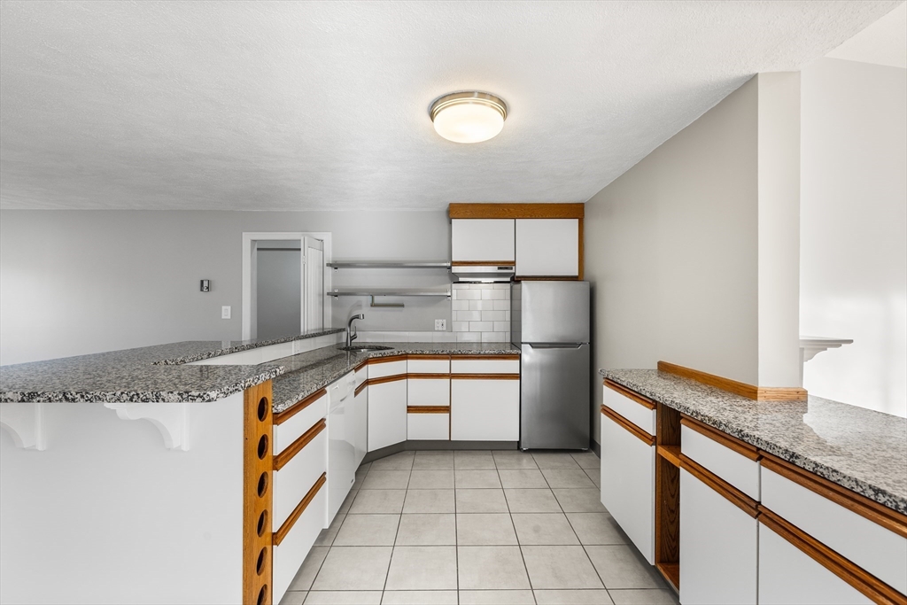 409 Haverhill Street Reading, MA 01867 - Photo 36 of 42 a large kitchen with granite countertop a sink and a stove top oven