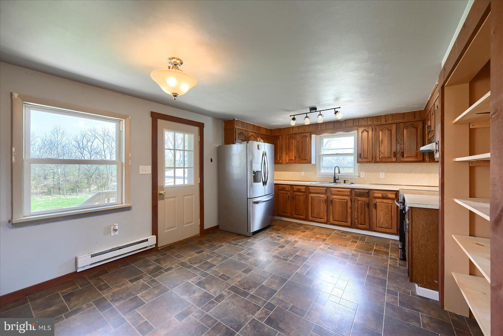 1144 Centennial Road New Oxford, PA 17350 - Photo 12 of 40 a kitchen with stainless steel appliances granite countertop a refrigerator a sink dishwasher a stove and a dining table with wooden floor
