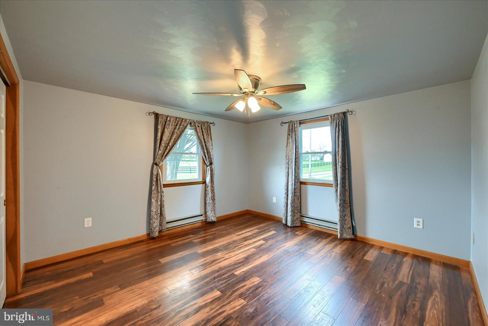 1144 Centennial Road New Oxford, PA 17350 - Photo 21 of 40 an empty room with wooden floor chandelier fan and windows