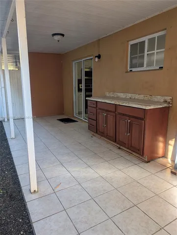 a view of kitchen with granite countertop cabinets and sink
