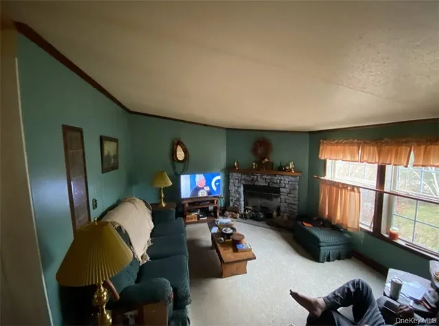 a living room with furniture fireplace and a window