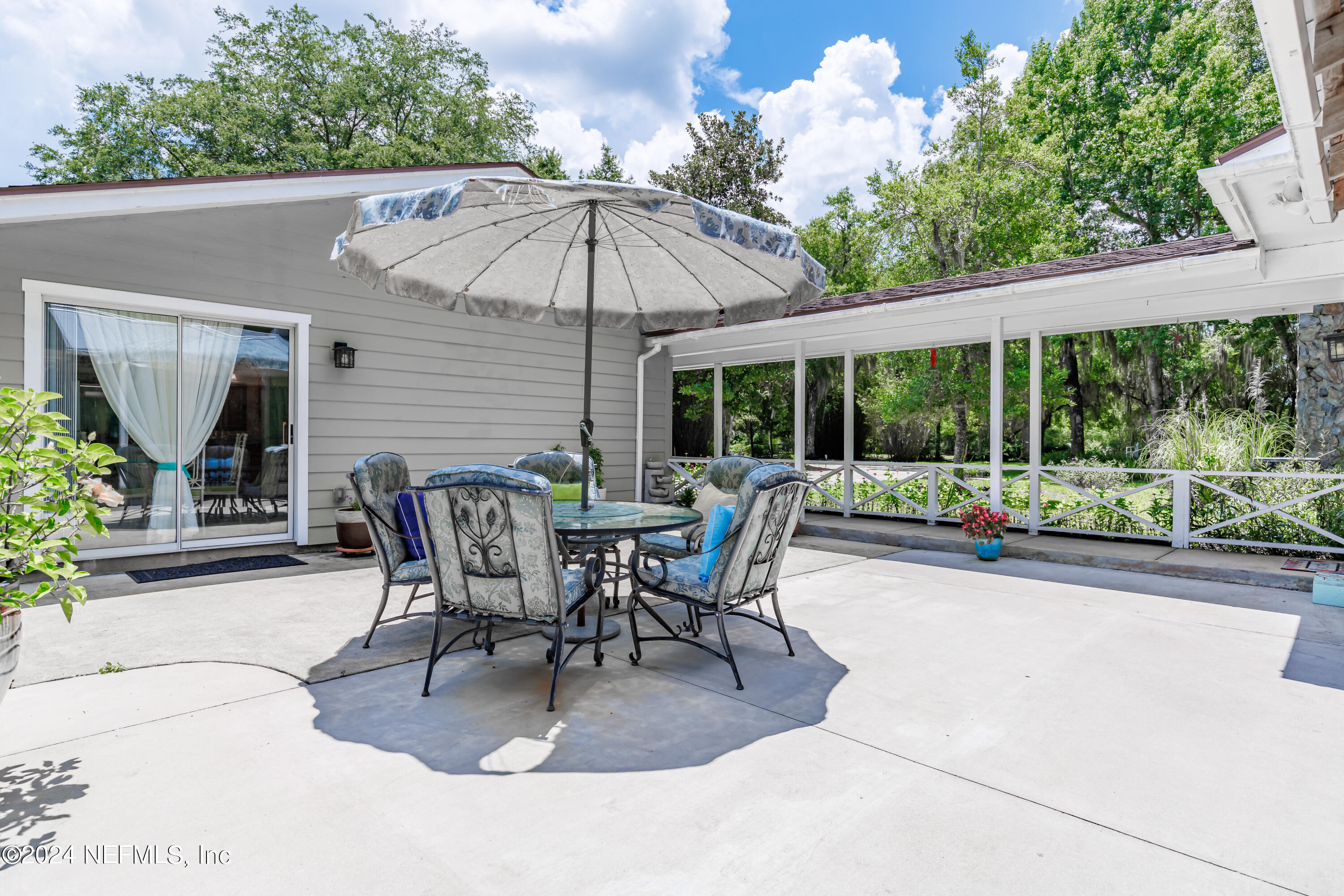 6070 Datil Pepper Road St. Augustine, FL 32086 - Photo 48 of 73 a view of a patio with a table and chairs under an umbrella