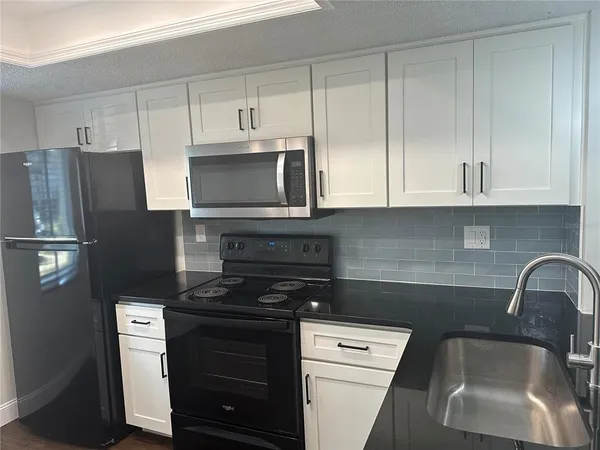 a kitchen with a sink stove and cabinets