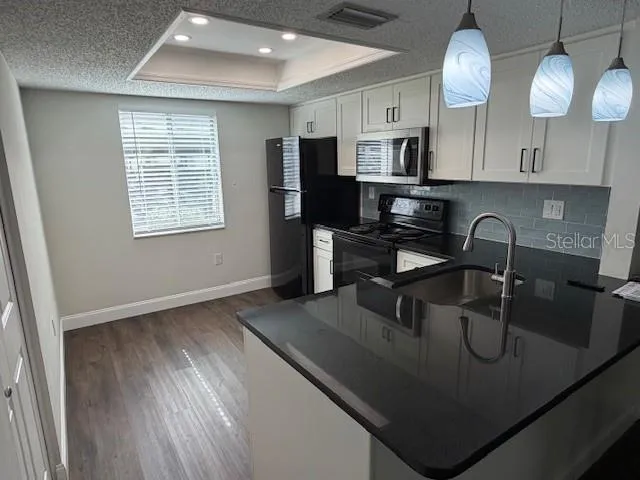 a kitchen with a sink stove and cabinets