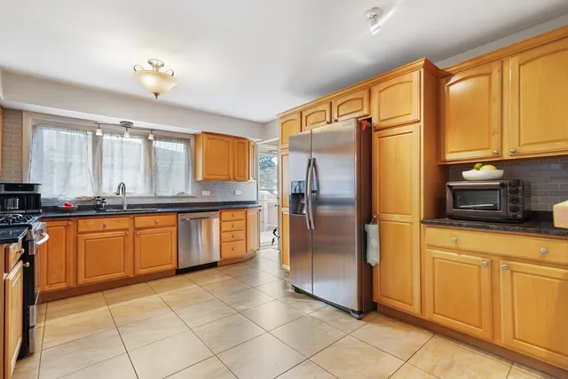 a kitchen with stainless steel appliances granite countertop a refrigerator and a sink