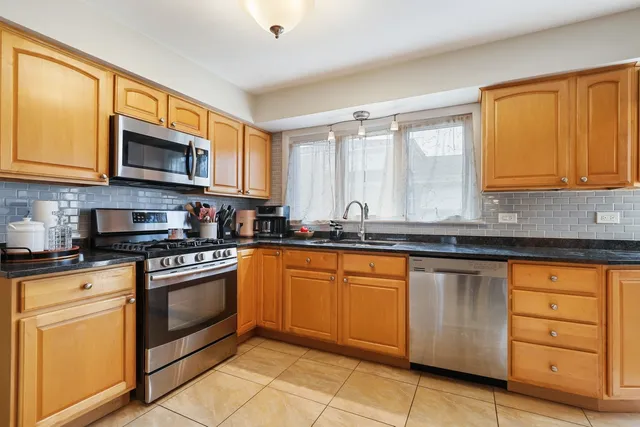 a kitchen with stainless steel appliances granite countertop a stove sink and cabinets