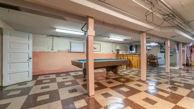 a dining hall with stainless steel appliances a dining table and chairs with wooden floor