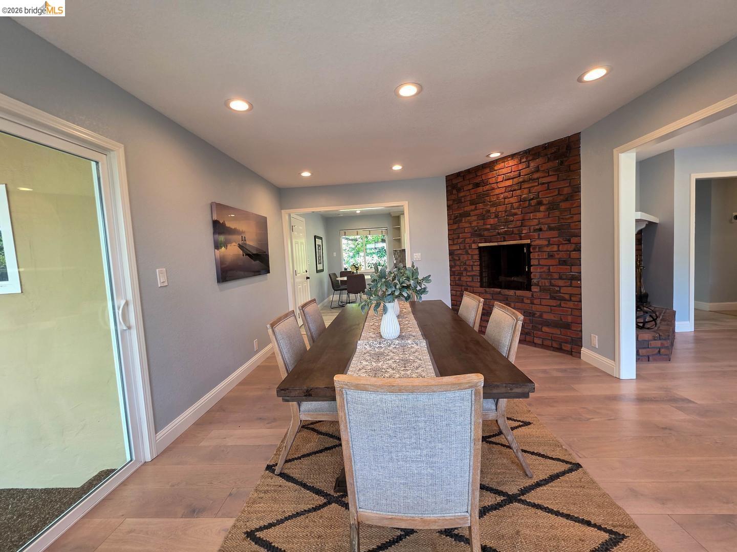 965 Springer Road Los Altos, CA 94024 - Photo 11 of 31 Interior dining space featuring a prominent brick-clad fireplace with an inset firebox