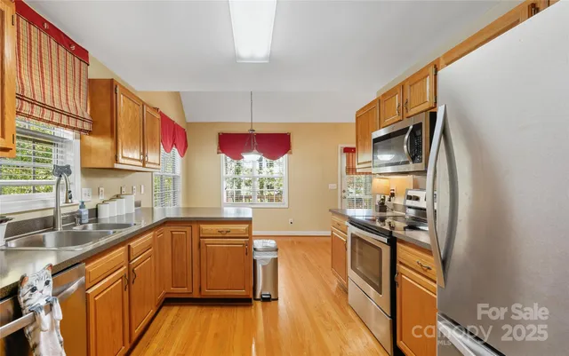 a kitchen with stainless steel appliances granite countertop a sink stove and refrigerator