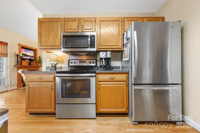 a kitchen with stainless steel appliances granite countertop a refrigerator stove and microwave