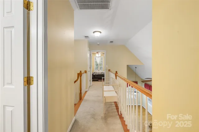 a view of a hallway with wooden floor and staircase